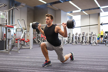 Image showing young man flexing muscles with barbell in gym