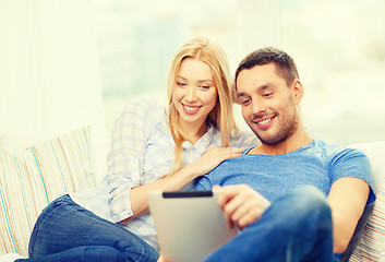 Image showing smiling happy couple with tablet pc at home