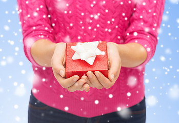 Image showing close up of woman in pink sweater holding gift box