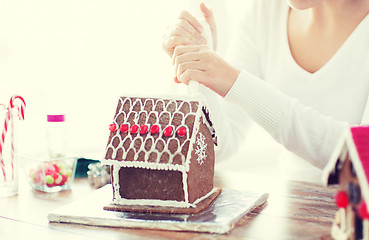 Image showing close up of woman making gingerbread house at home