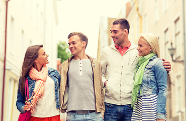 Image showing group of smiling friends walking in the city