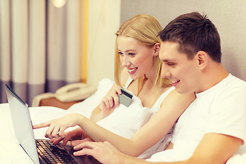 Image showing couple in bed with laptop computer and credit card