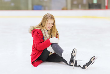 Image showing young woman fell down on skating rink