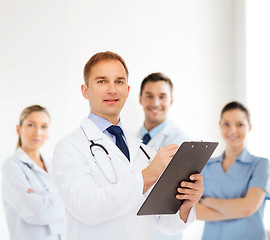 Image showing smiling male doctor with clipboard and stethoscope