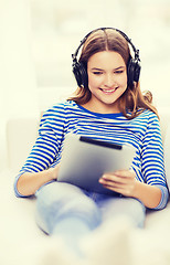 Image showing girl with tablet pc and headphones at home