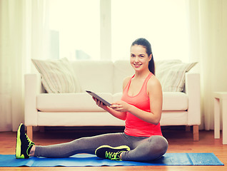 Image showing smiling teenage girl streching on floor at home