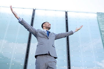 Image showing young smiling businessman over office building