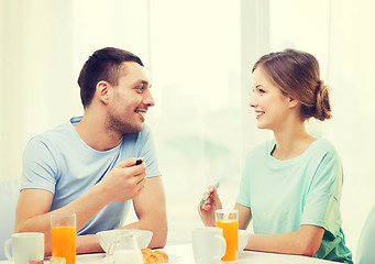 Image showing smiling couple having breakfast at home