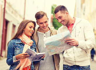 Image showing group of smiling friends with city guide and map