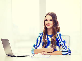 Image showing smiling teenage girl laptop computer and notebook