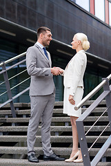 Image showing smiling businessmen shaking hands on street