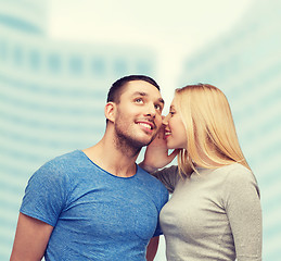 Image showing smiling girlfriend telling boyfriend secret