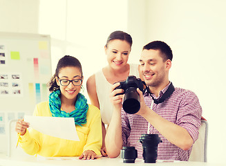 Image showing smiling team with photocamera working in office