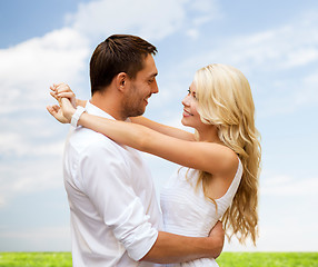 Image showing happy couple hugging over natural background