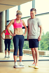 Image showing smiling man and woman with scales in gym