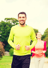Image showing smiling couple running outdoors
