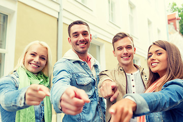 Image showing group of smiling friends in city pointing finger