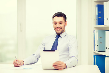 Image showing smiling businessman with tablet pc and documents