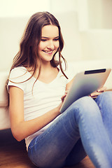 Image showing smiling teenage girl with tablet pc at home