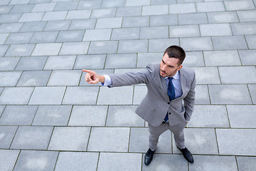 Image showing young smiling businessman outdoors from top