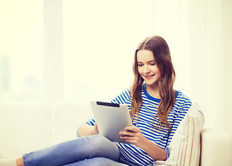 Image showing smiling teenage girl with tablet pc at home