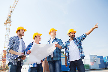 Image showing group of builders with tablet pc and blueprint