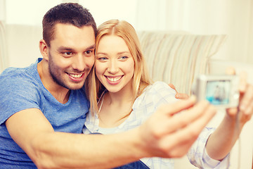 Image showing smiling couple taking picture with digital camera