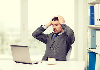 Image showing busy businessman with laptop and coffee