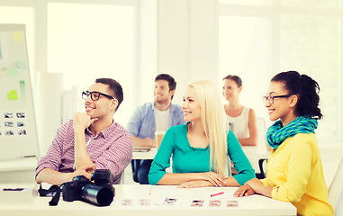 Image showing smiling team with photocamera working in office