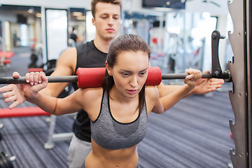 Image showing man and woman with barbell flexing muscles in gym