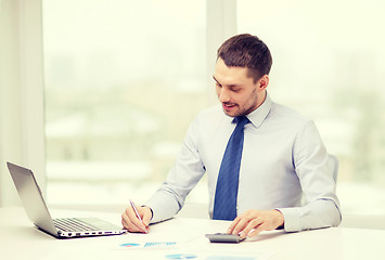 Image showing smiling businessman with laptop and documents