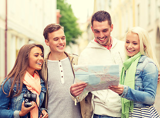 Image showing group of smiling friends with map and photocamera