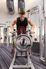 Image showing young man exercising on t-bar row machine in gym