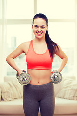 Image showing smiling girl exercising with dumbbells