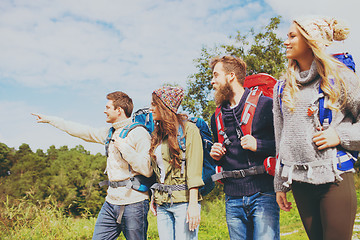 Image showing group of smiling friends with backpacks hiking