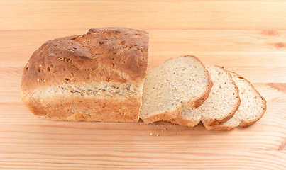 Image showing Crusty loaf of fresh bread and three slices