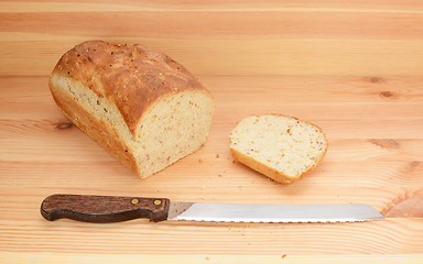 Image showing Bread knife with freshly sliced loaf of bread 