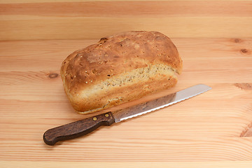 Image showing Fresh loaf of oat and linseed bread with a bread knife