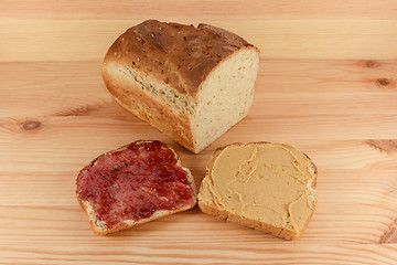 Image showing Cut loaf of fresh bread with jelly and peanut butter slices