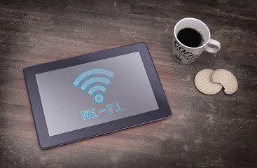 Image showing Tablet with Wi-Fi connection on a wooden desk