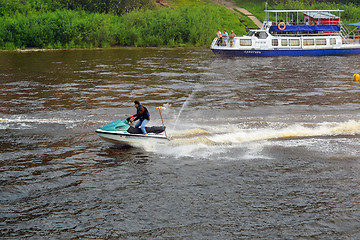 Image showing The man on a hydrocycle floats down the river.