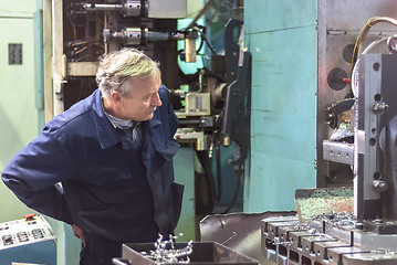 Image showing Elderly worker watches on milling machine work