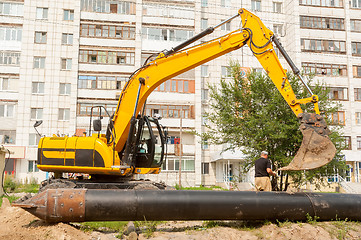 Image showing Using of excavator as crane for raising of pile