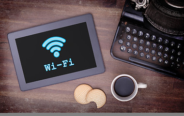 Image showing Tablet with Wi-Fi connection on a wooden desk