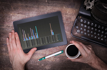 Image showing Tablet touch computer gadget on wooden table, graph