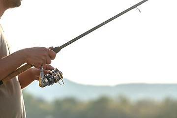 Image showing Modern clean fishing rod in hands