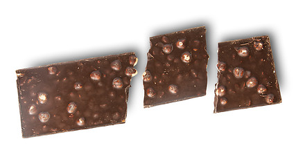 Image showing Broken tiles of dark chocolate with whole hazelnuts