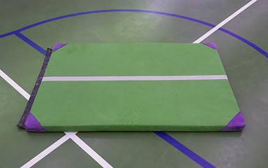 Image showing Very old green mat on a blue court