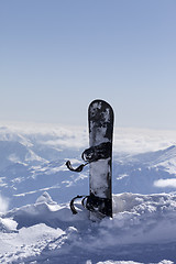 Image showing Snowboard in snow on off-piste slope at sun day