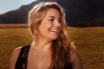 Image showing Portrait of a laughing blond girl with golden hair.